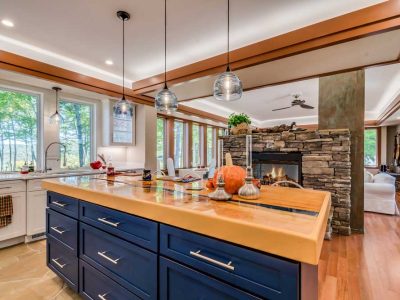 Open Kitchen With Stand Alone Fireplace In The Middle Of The Room